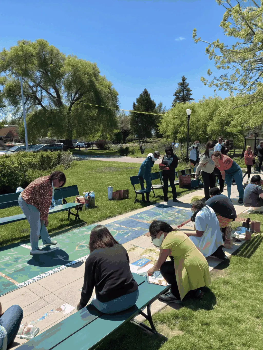 A photograph of a community event at ASLR ATELIER CAMPO, showing diverse participants interacting and learning about the artistic heritage, highlighting community engagement.